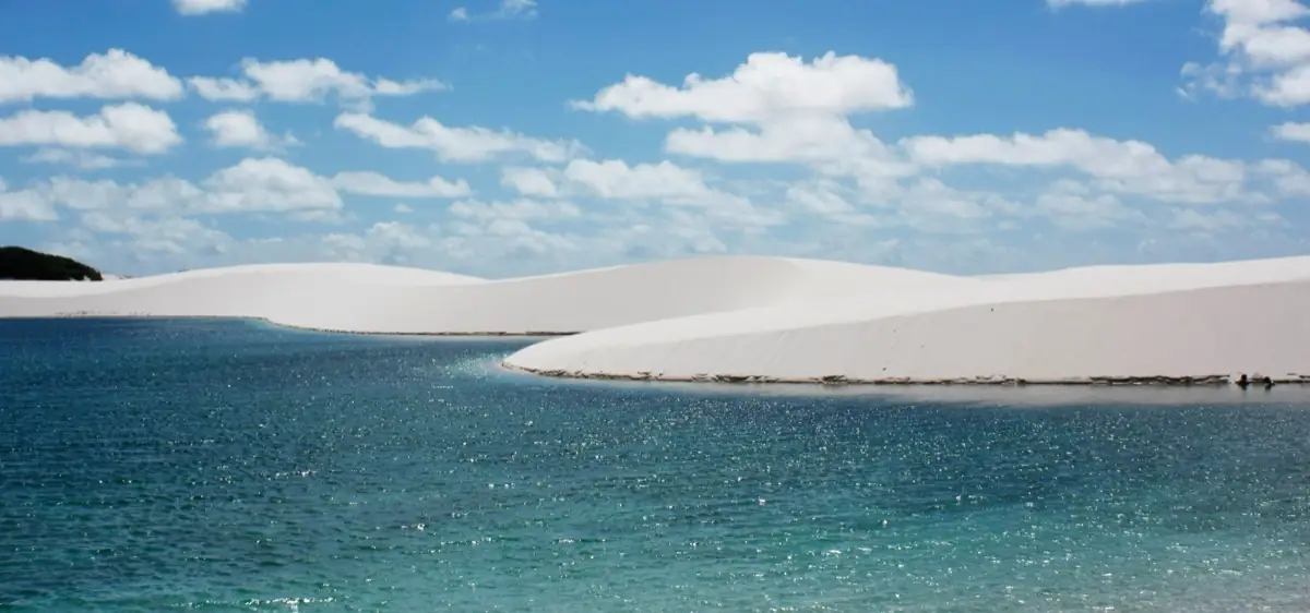 Lagoa de água turquesa junto à duna, no caminho de Atins