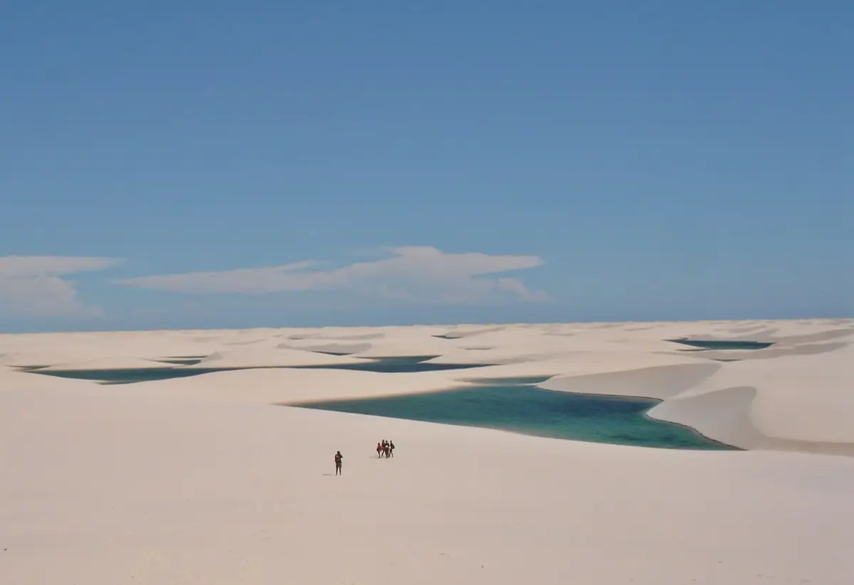 Campo de dunas com lagoas e pessoas ao longe, dando a escala do parque